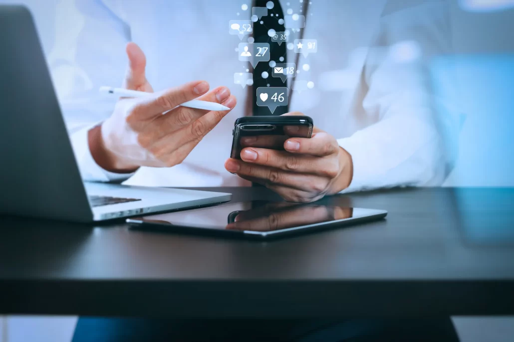Social media management service showcasing engagement on smartphone with like and comment icons displayed.